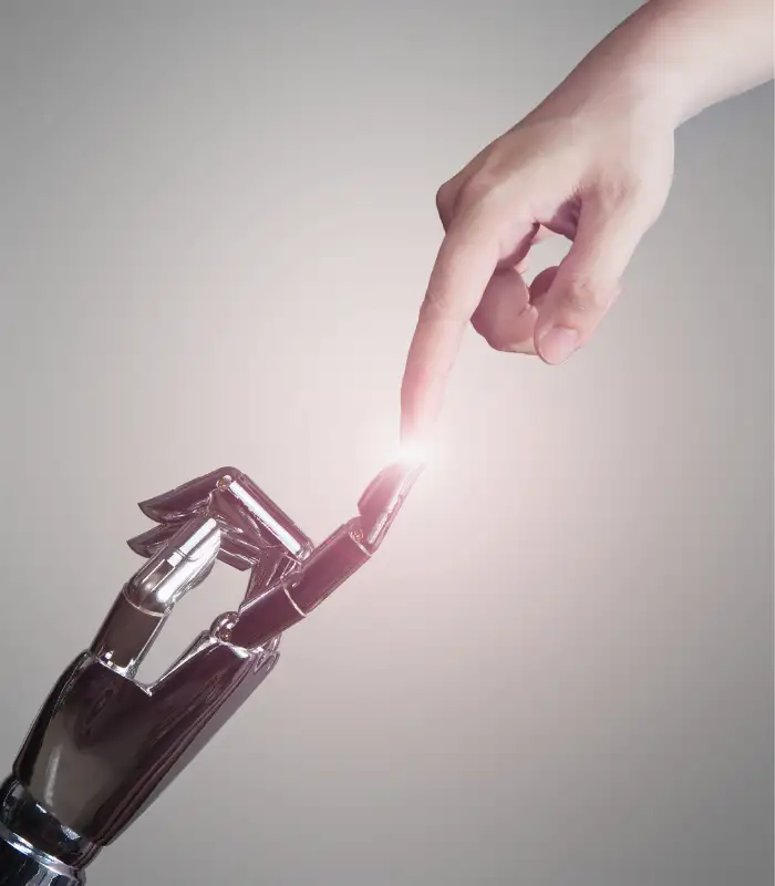 Die Zeigefinger einer menschlichen Hand und einer Roboterhand berühren sich in der Mitte des Bildes.